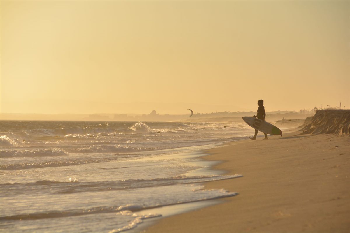 Surfers on the beach at sunset after a session at a Taghazout surf camp