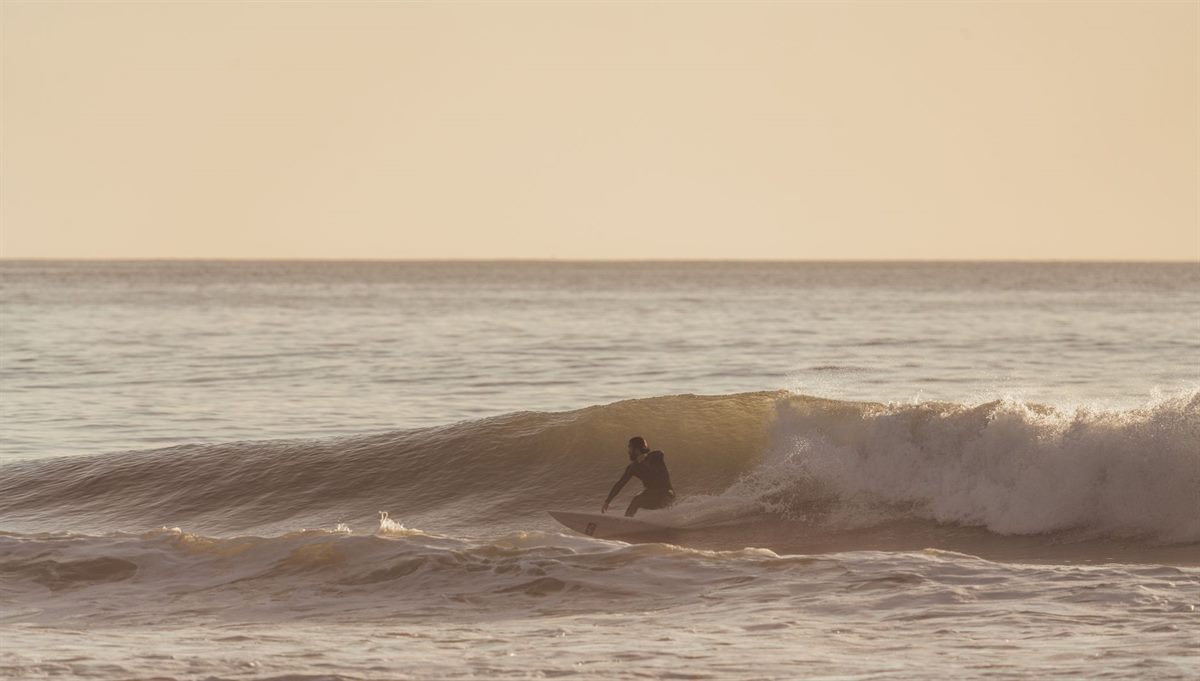 Surfer riding the long right-hand wave at Imsouane Bay, Morocco