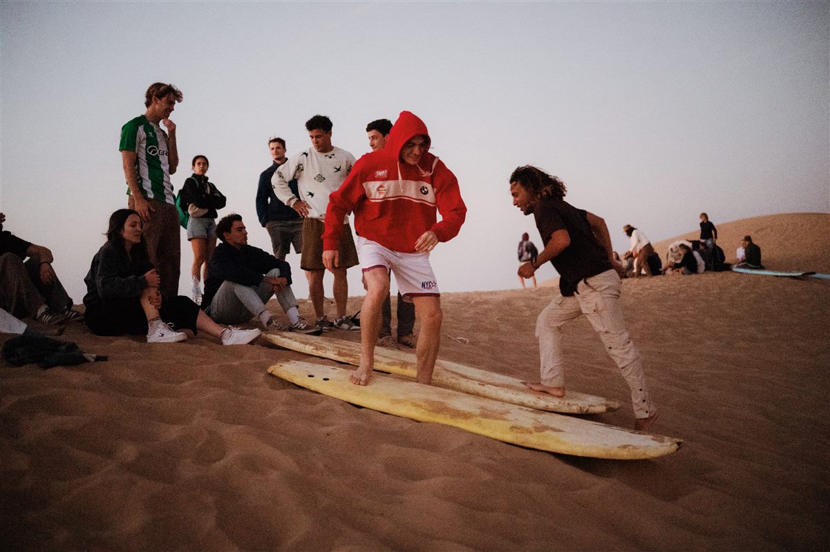 Sandboarding on the dunes near Taghazout at sunset