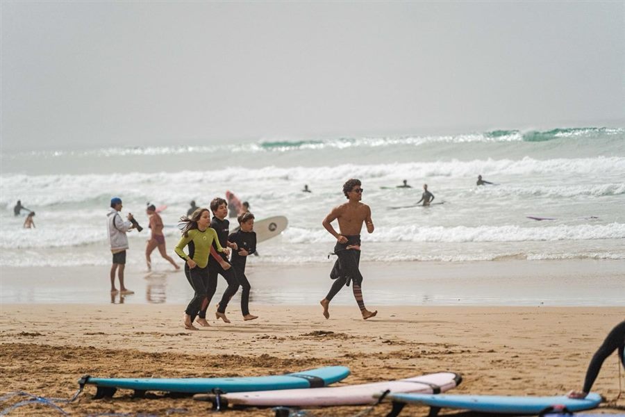 Family enjoying a private group surf lesson on the beach in Taghazout
