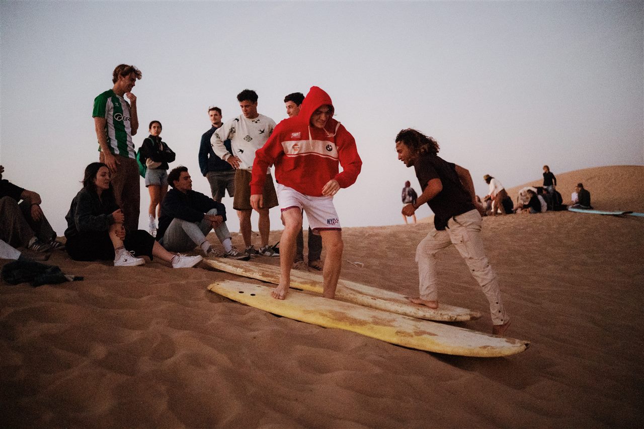 Sandboarding instructor teaching a group on the desert dunes near Taghazout