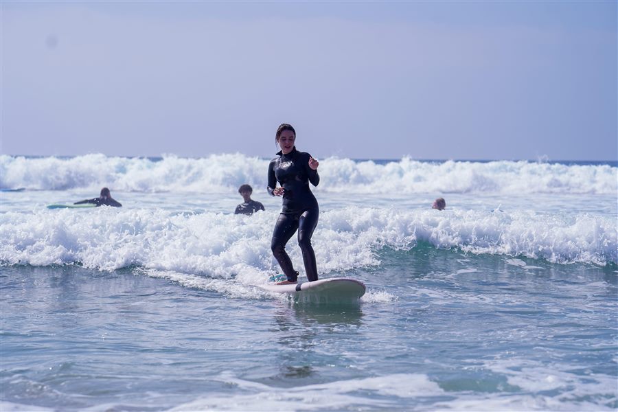 Beginner catching a wave with an instructor during a surf lesson in Taghazout