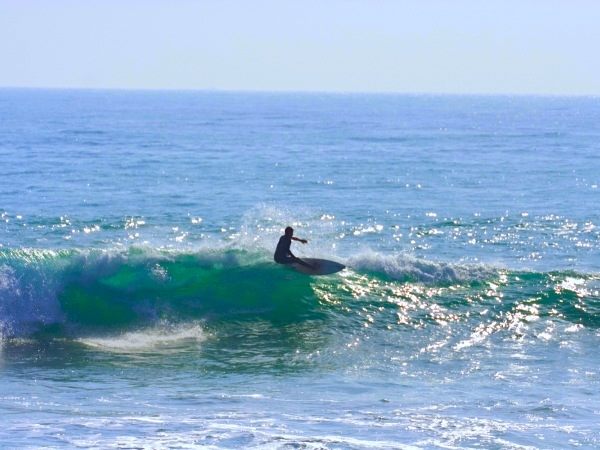 Surfer riding a wave at La Source surf spot near Taghazout during a guided session